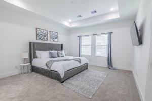 ein Schlafzimmer mit einem Bett und einem TV in der Unterkunft Luxury Home Near DTW/ Med Ctr in Houston