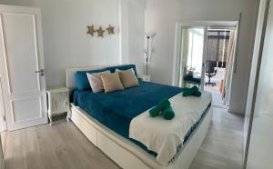 a bedroom with a blue bed and a mirror at Sun & Sea rooftop in Costa da Caparica
