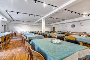 une salle de banquet avec des tables et des chaises bleues dans l'établissement Panorama, à Krynica-Zdrój
