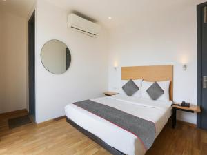 a bedroom with a large bed and a mirror at Super Townhouse 080 Meera Bagh in New Delhi