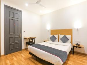um quarto com uma cama grande e uma porta em Super Townhouse 080 Meera Bagh em Nova Deli