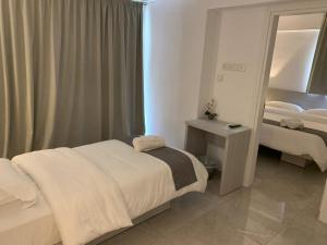 a hotel room with two beds and a mirror at La Veranda Hotel in Larnaka