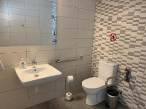 a bathroom with a white toilet and a sink at La Veranda Hotel in Larnaka