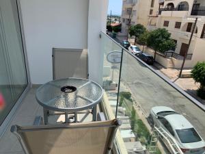 een glazen tafel op het balkon van een gebouw bij La Veranda Hotel in Larnaka