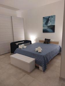 een slaapkamer met een bed met twee knuffels erop bij La Sebastiana in Porto Torres