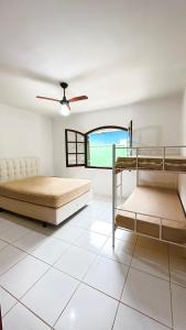 1 dormitorio con 2 literas y ventana en CASA VERDE, en Ubatuba