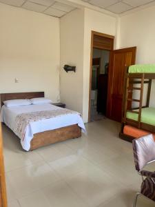 1 dormitorio con 1 cama y 1 silla en Hostal Zaguán Caldense, en Manizales