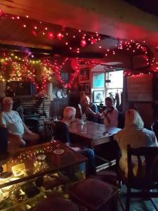 a group of people sitting in a restaurant with christmas lights at Kingfisher Lodge & Pub in Castleconnell