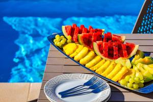 a tray of fruit on a table next to a pool at Villa Lia Chania with private ecologic pool and amazing view! in Chania