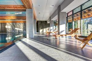 an indoor pool with rocking chairs and windows at Panorama in Krynica Zdrój