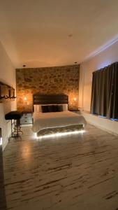a bedroom with a bed and a stone wall at Suites Campestres Montebello in Bernal