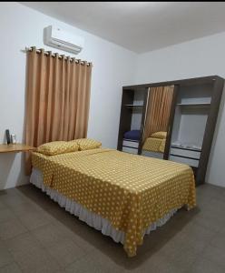 - une chambre avec un lit doté d'une couverture jaune polka dans l'établissement Bom pra ficar, à Limoeiro do Norte
