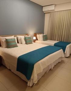 2 bedden in een hotelkamer met zitplaatsen bij APTO Thermas Water Park Resort in São Pedro