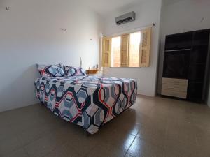 - une chambre avec un lit doté d'une couette colorée et d'une télévision dans l'établissement Bom pra ficar, à Limoeiro do Norte