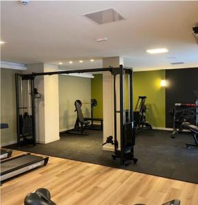 een fitnessruimte met loopbanden in een kamer met groene muren bij APTO Thermas Water Park Resort in São Pedro
