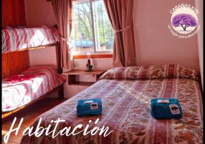 Un dormitorio con una cama con dos bolsas encima. en Cabañas Kiri, en Santa Rosa de Calamuchita