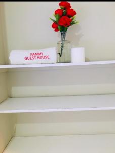 een plank met een vaas met bloemen erop bij Pammy Guest House in Richards Bay