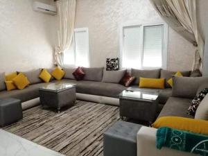 a living room with a gray couch and yellow pillows at Rabie in Fez