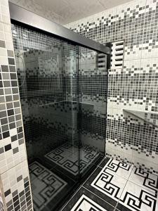 um chuveiro numa casa de banho com azulejos pretos e brancos em Recanto no jóia em Ilhéus