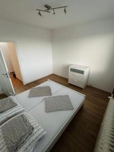 una camera da letto con un letto bianco con due cuscini sopra di plne vybavený 3 izbový apartmán a Stropkov