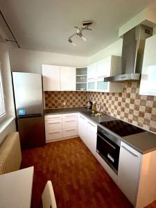 una cucina con armadietti bianchi e stufa nera di plne vybavený 3 izbový apartmán a Stropkov
