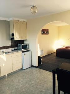 a kitchen with a refrigerator and a bed in a room at Ferry Motel in Christchurch