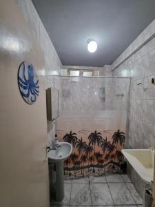 La salle de bains est pourvue d'une douche, d'un lavabo et d'une baignoire. dans l'établissement Kitnet Ubatuba, à Ubatuba