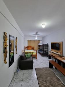 a living room with a couch and a bed at Kitnet Ubatuba in Ubatuba