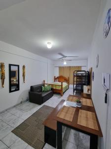 uma sala de estar com um sofá e uma mesa em Kitnet Ubatuba em Ubatuba