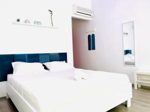 two white beds in a bedroom with a blue headboard at Cozy Hideout - Condo Hotel in Timişoara