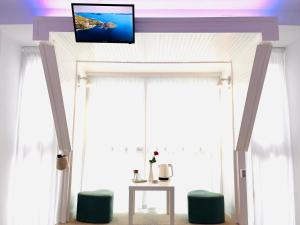 a room with a tv above a window with a table at Cozy Hideout - Condo Hotel in Timişoara