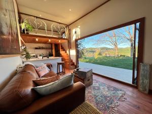 a living room with a couch and a large window at Te Awa Mata o' Tukituki in Havelock North