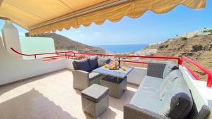 a balcony of a house with a table and chairs at Inagua Sol apartment in Puerto Rico de Gran Canaria