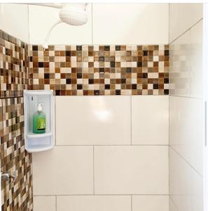 un bagno con dispenser di sapone nella doccia di Guarajuba sitiofelizcidade a Guarajuba