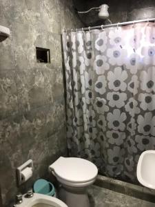 een badkamer met toilet en douchegordijn bij Alojamiento La Mamu 2 in Paso de la Patria