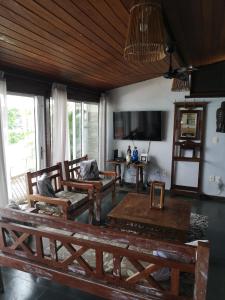 sala de estar con muebles de madera y TV de pantalla plana en Coco Beach Apart, en Natal