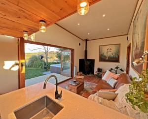 uma cozinha e sala de estar com um sofá e um lavatório em Te Awa Mata o' Tukituki em Havelock North