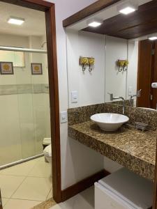 a bathroom with a sink and a toilet and a mirror at Pousada Reserva Penedo in Penedo