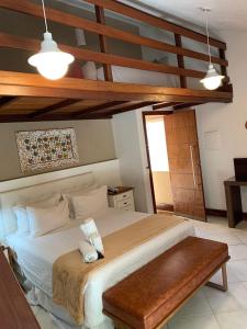 a bedroom with a large bed with a wooden ceiling at Pousada Reserva Penedo in Penedo