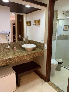 a bathroom with a sink and a toilet at Pousada Reserva Penedo in Penedo