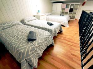 three beds in a room with wood floors at Casa Rural Villa Arizona en Cartagena in Murcia