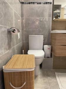Duplex Marigot centre-ville في ماريجوت: حمام مع مرحاض وطاولة خشبية
