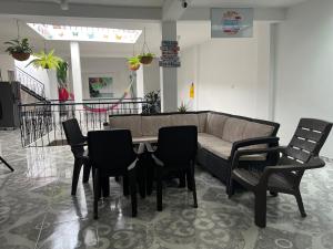 a table and chairs in a room with a couch at Helena Hostel in Cali