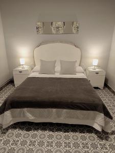 ATALAYA DEL RÍO في فالديروبريس: غرفة نوم بسرير كبير مع مواقف ليلتين