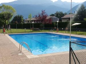 una grande piscina blu in un cortile di VILLANUA ACOGEDOR PISO CON GARAJE, PADEL Y PISCINA a Villanúa