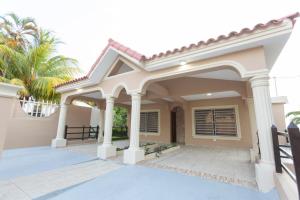 a house with a porch and columns at MB Apartment - B in San Felipe de Puerto Plata