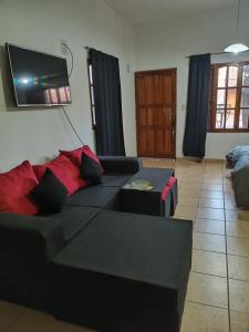 a living room with a black couch and a flat screen tv at monoambiente malbec ubicacion privilegiada no mascotas in Mendoza