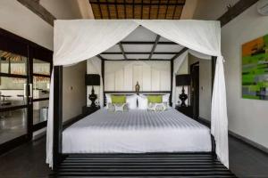 ein Schlafzimmer mit einem großen weißen Bett mit Baldachin in der Unterkunft Вилла в Пуэрто-Плата in Sosúa