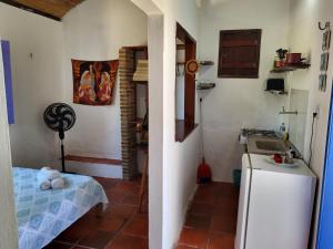 una pequeña cocina con fregadero y nevera. en Chalé Flor do ser, en Canoa Quebrada