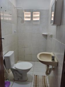 a bathroom with a toilet and a sink at Chalé Flor do Ser in Canoa Quebrada